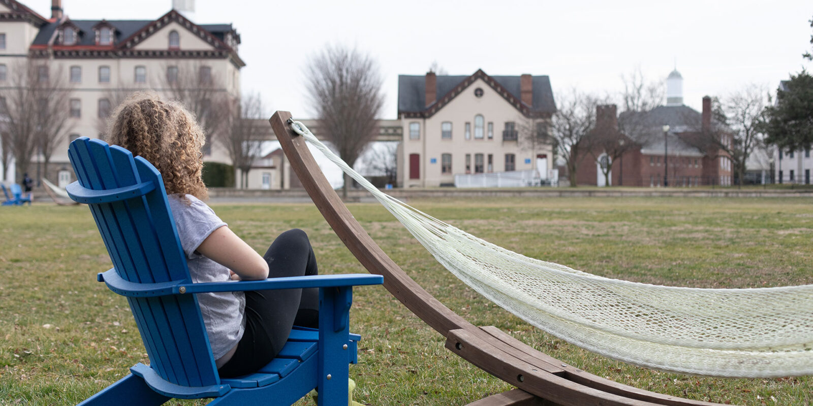 student in chair on university lawn