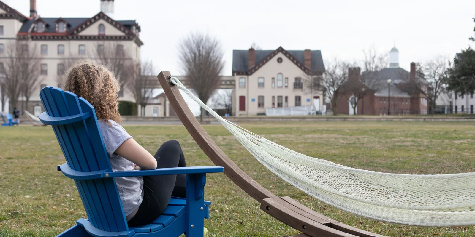 student in chair on university lawn