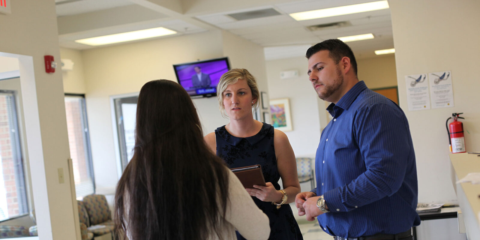 students in hall talking with staff