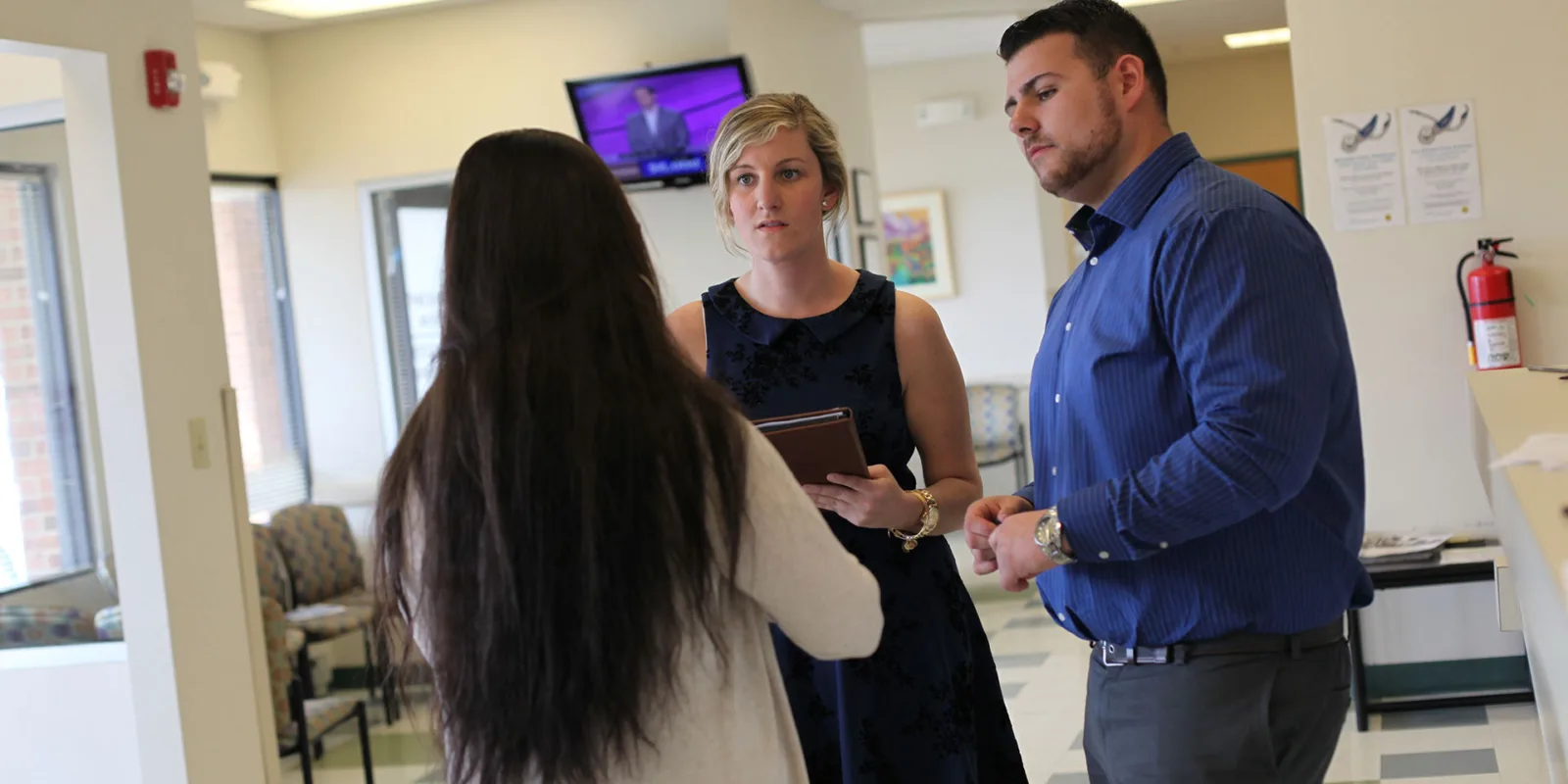 students in hall talking with staff