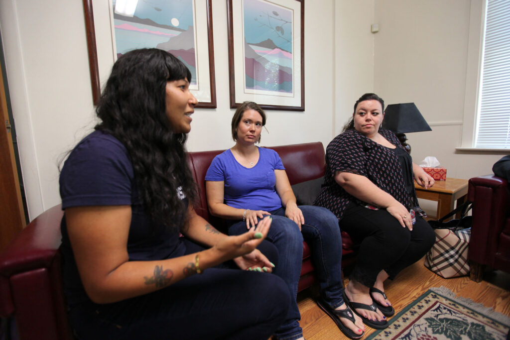 three women sitting in living room talking